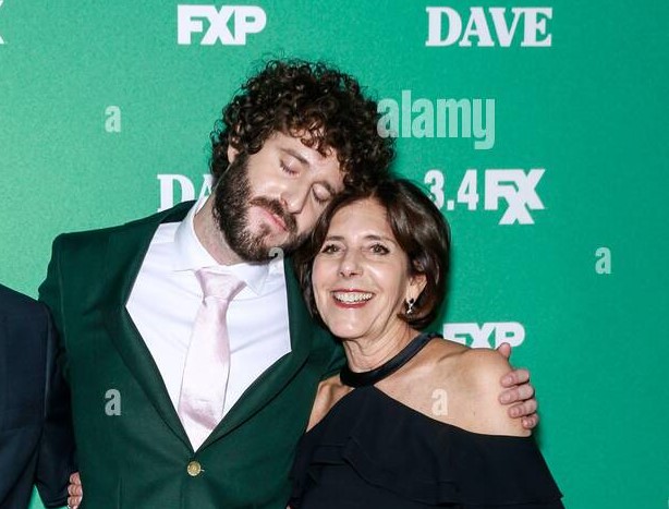 Lil Dicky posing and closing his eyes and Jeanne Burd smiling