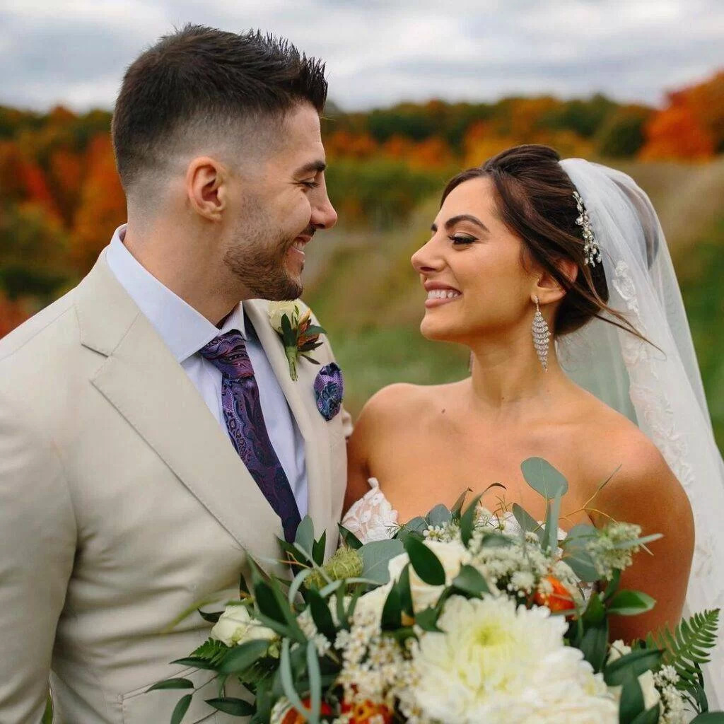 Emumita Bonita and Nickmercs looking at each other and smiling while wearing a wedding dress and suit