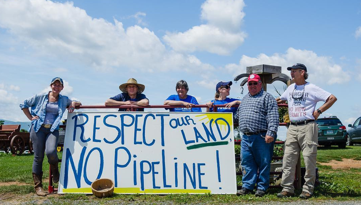 Six environmentalists, with a sign that says, ‘Respect our land. No pipeline!’