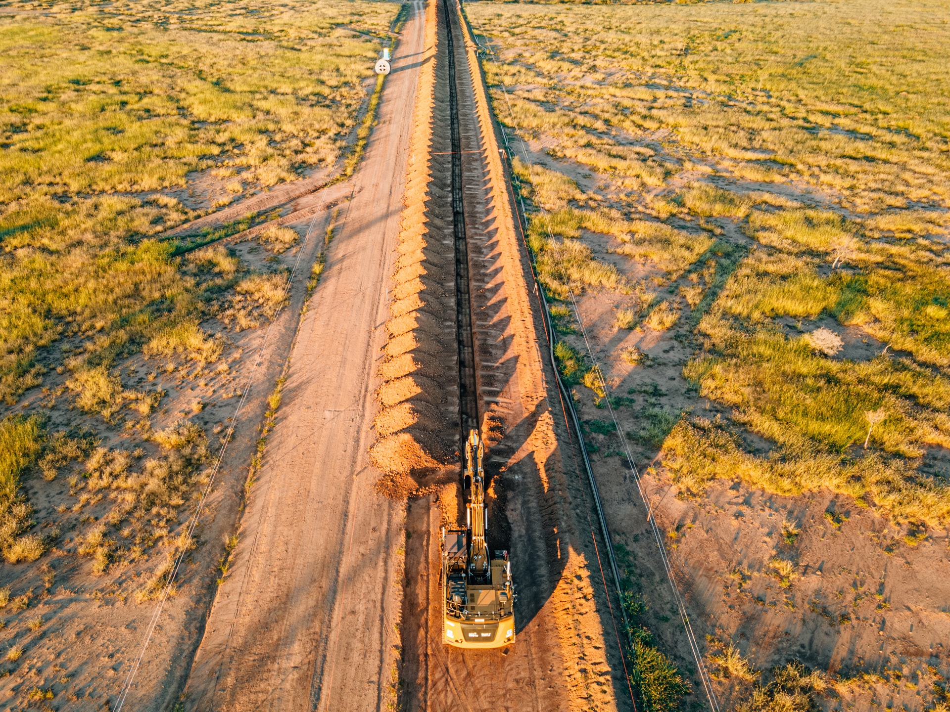 An autonomous excavator prepares trenches for an oil pipeline installation in Queensland, Australia