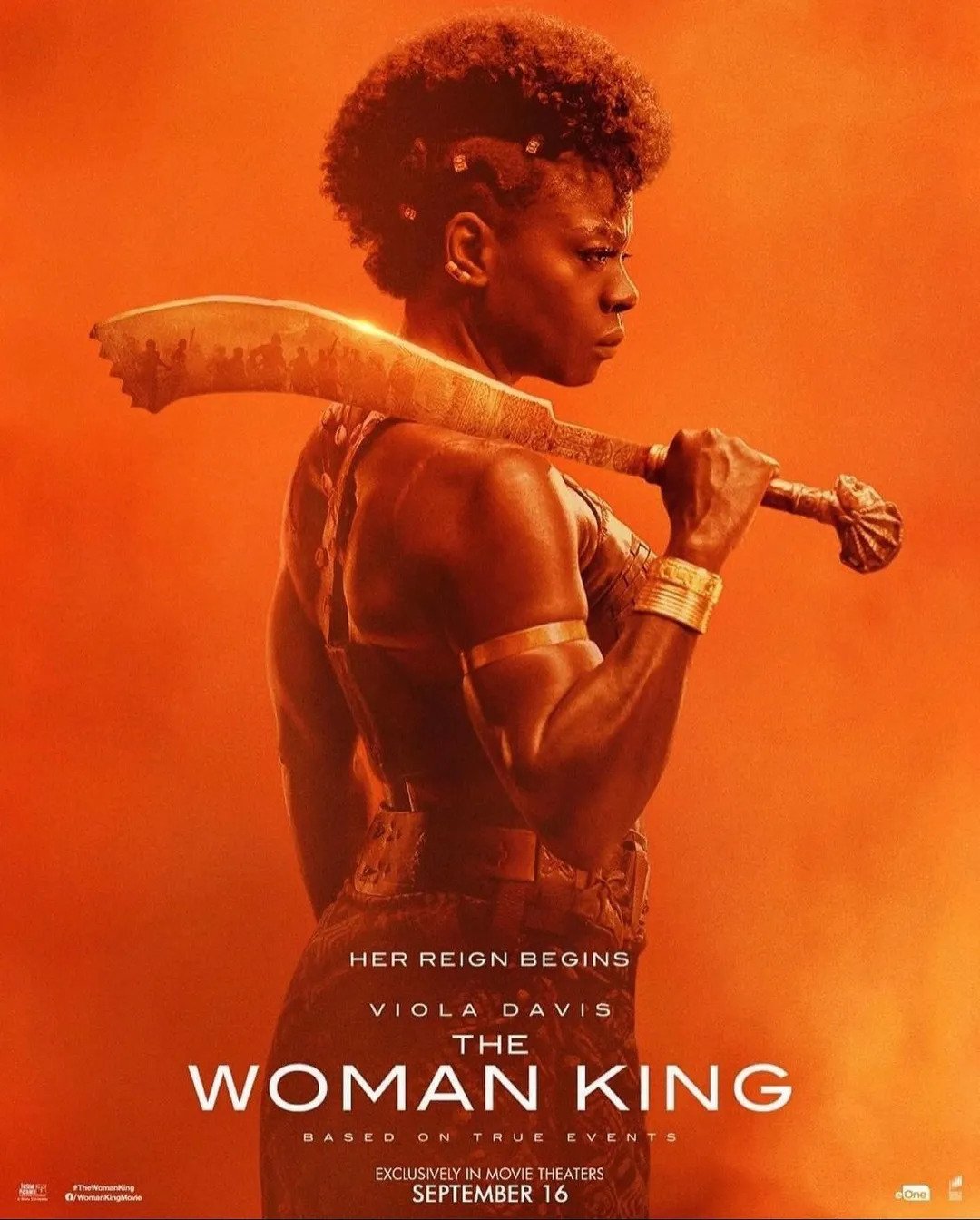 ‘The Woman King’ movie poster with a side view of Viola Davis holding a jungle bolo-like weapon