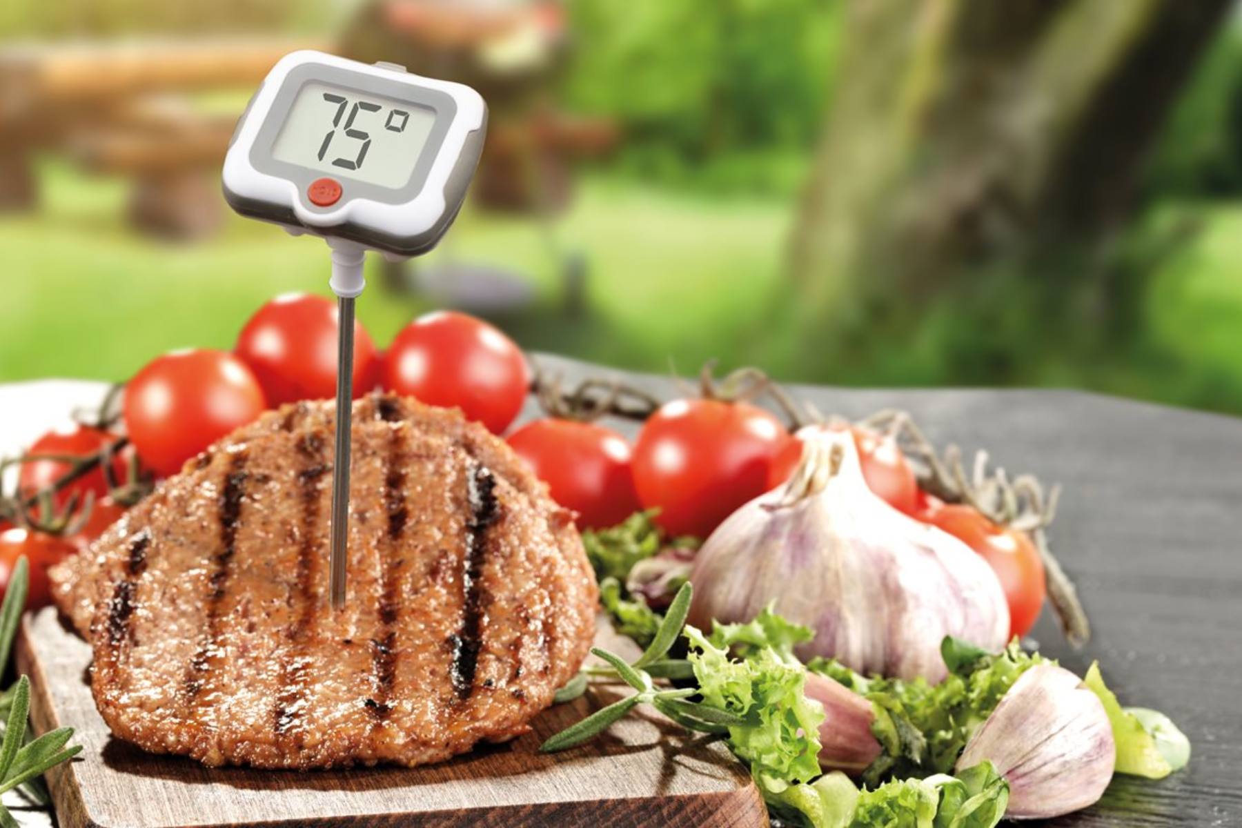 A meat with a temperature gauge that says "70°" and other vegetables nearby