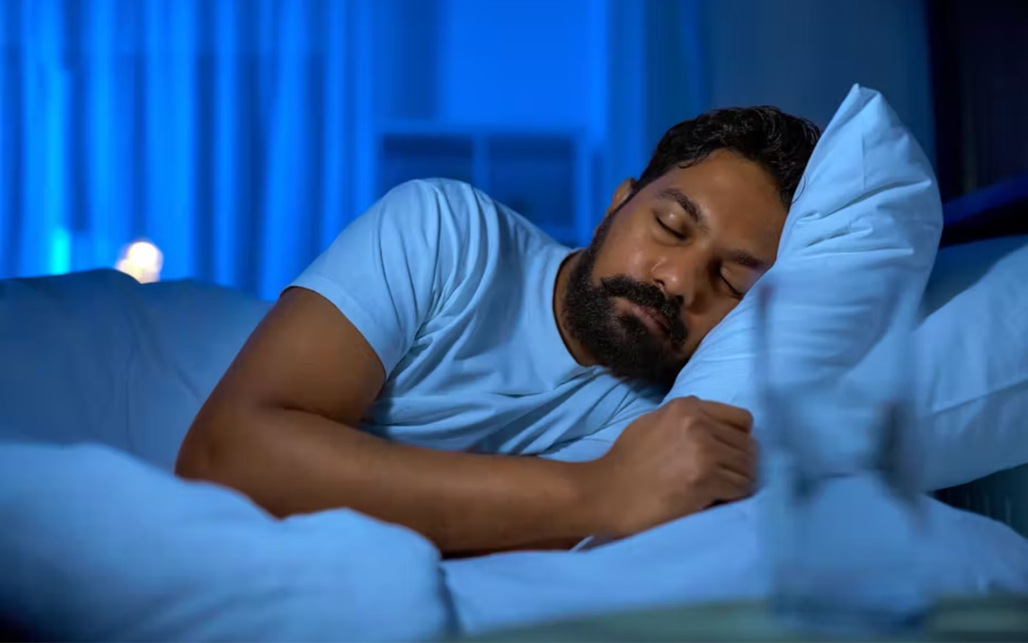 A man is sleeping while wearing a white t-shirt