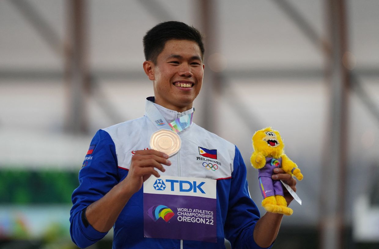 EJ Obuena holding his bronze medal while smiling on camera
