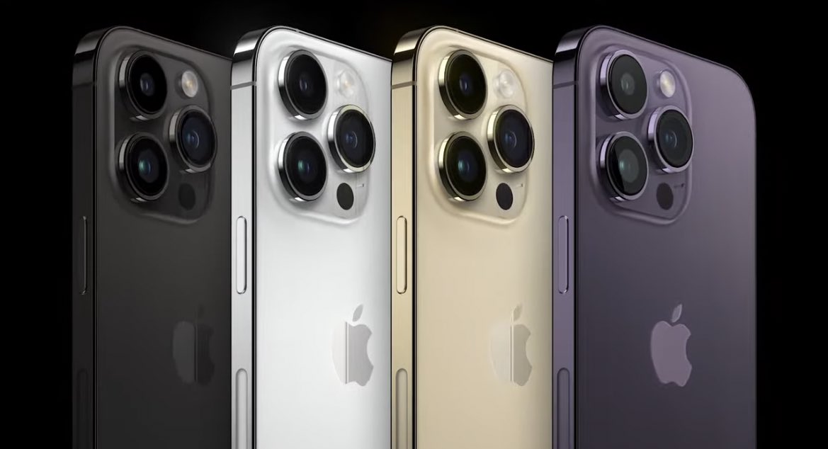 Upper half of the back of four iPhone 14 Pro in black, silver, gold and deep purple  