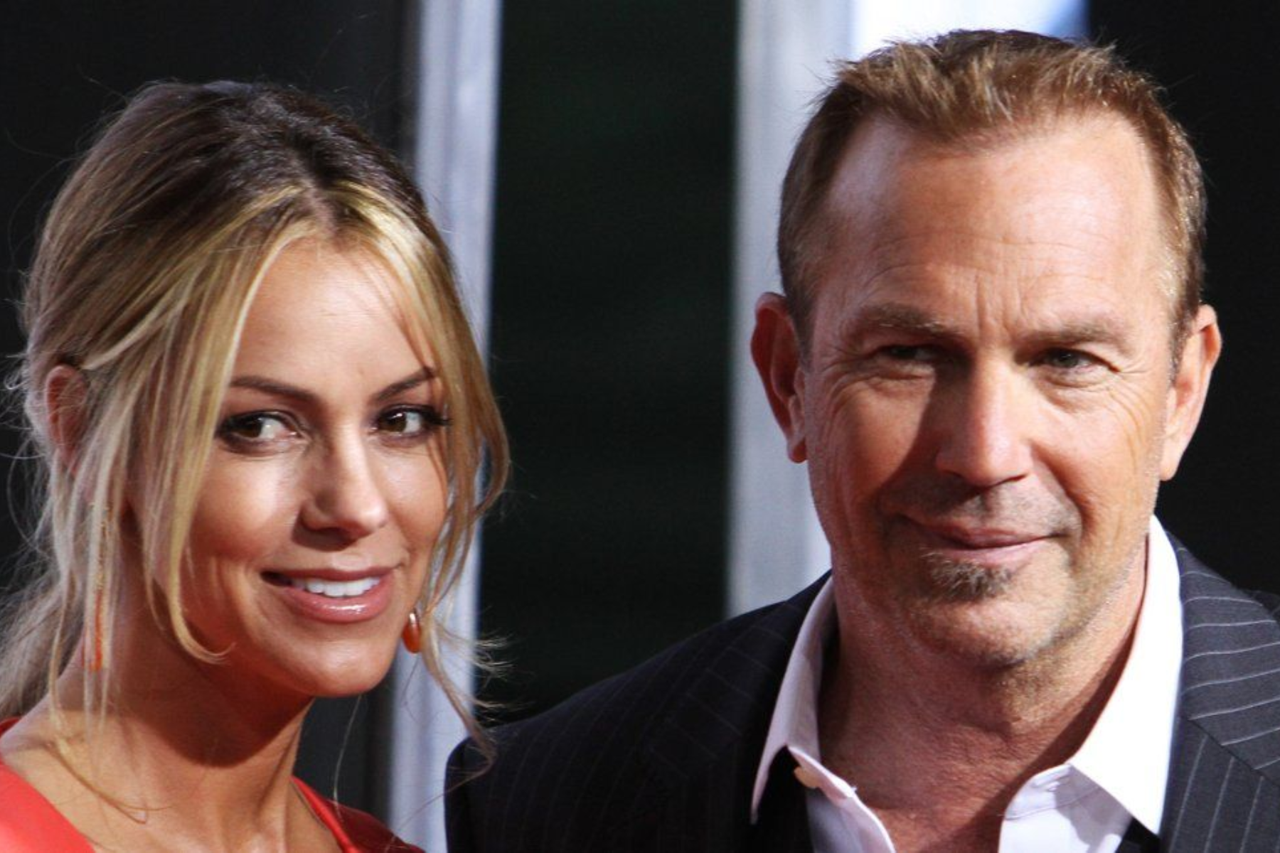 Christine Baumgartner and Kevin Costner are smiling and looking far away