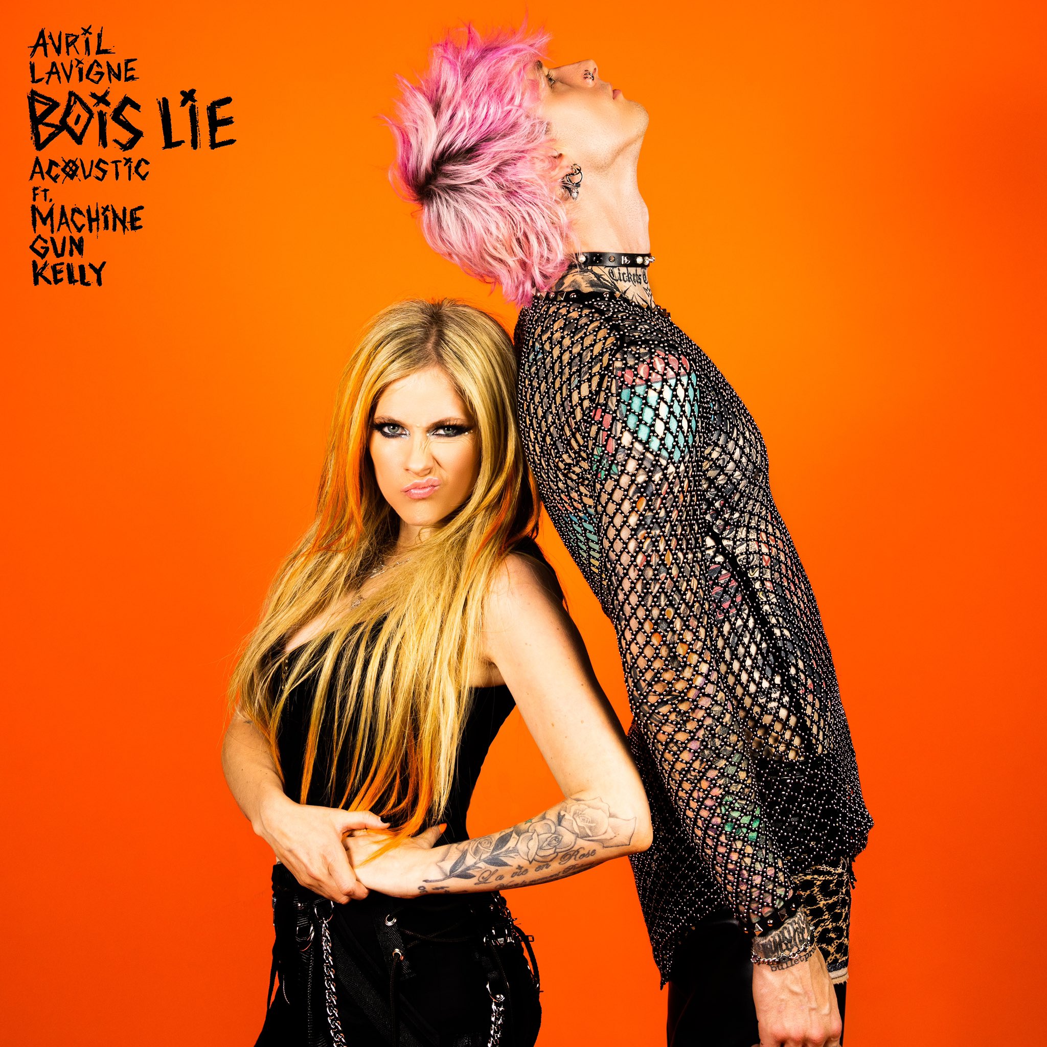 Avril Lavigne in black top and pants pouts as pink-haired Machine Gun Kelly in fishnet shirt leans backward
