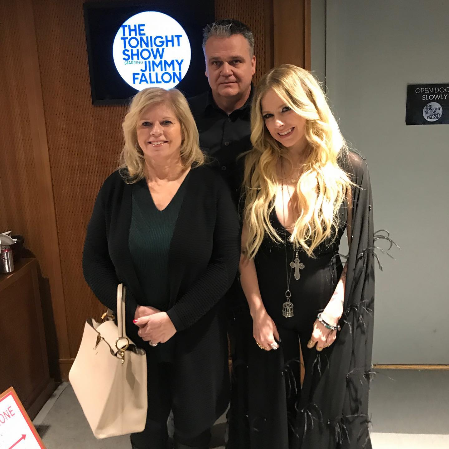 Avril Lavigne in black outfit with her parents at the backstage of ‘Tonight Show with Jimmy Fallon’