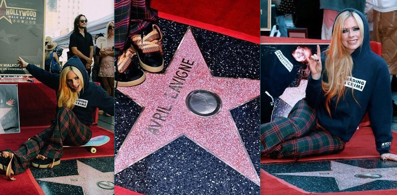Avril Lavigne in blue hoodie and plaid pants posing with her Hollywood Walk of Fame star