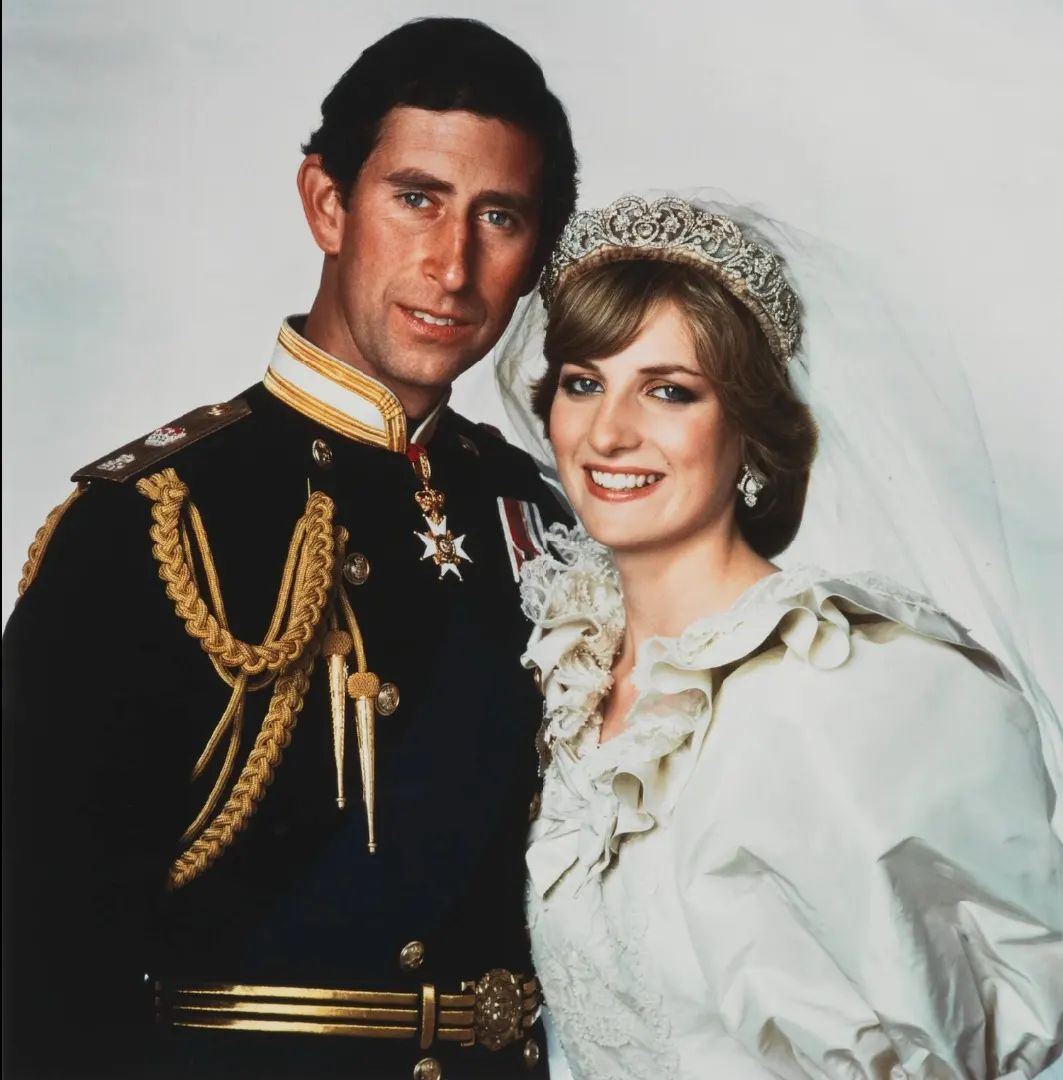 Charles in a Royal Navy commander’s uniform and Diana wearing a crown and an ivory silk taffeta wedding gown