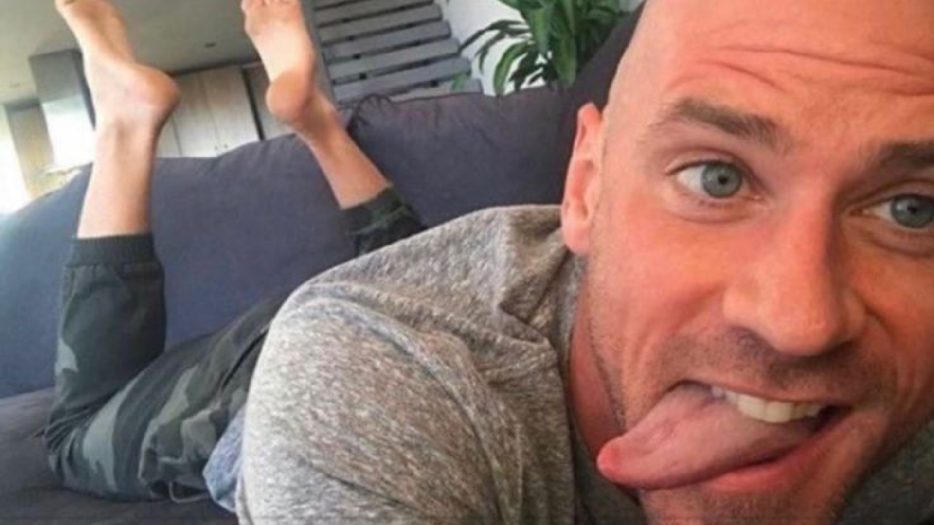 Johnny Sins lying in the couch and sticking his tongue out