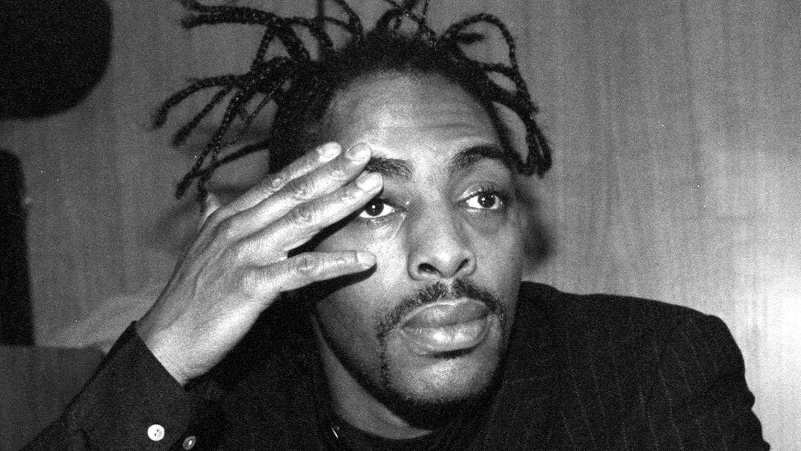 Coolio with braids and touching his eyebrow
