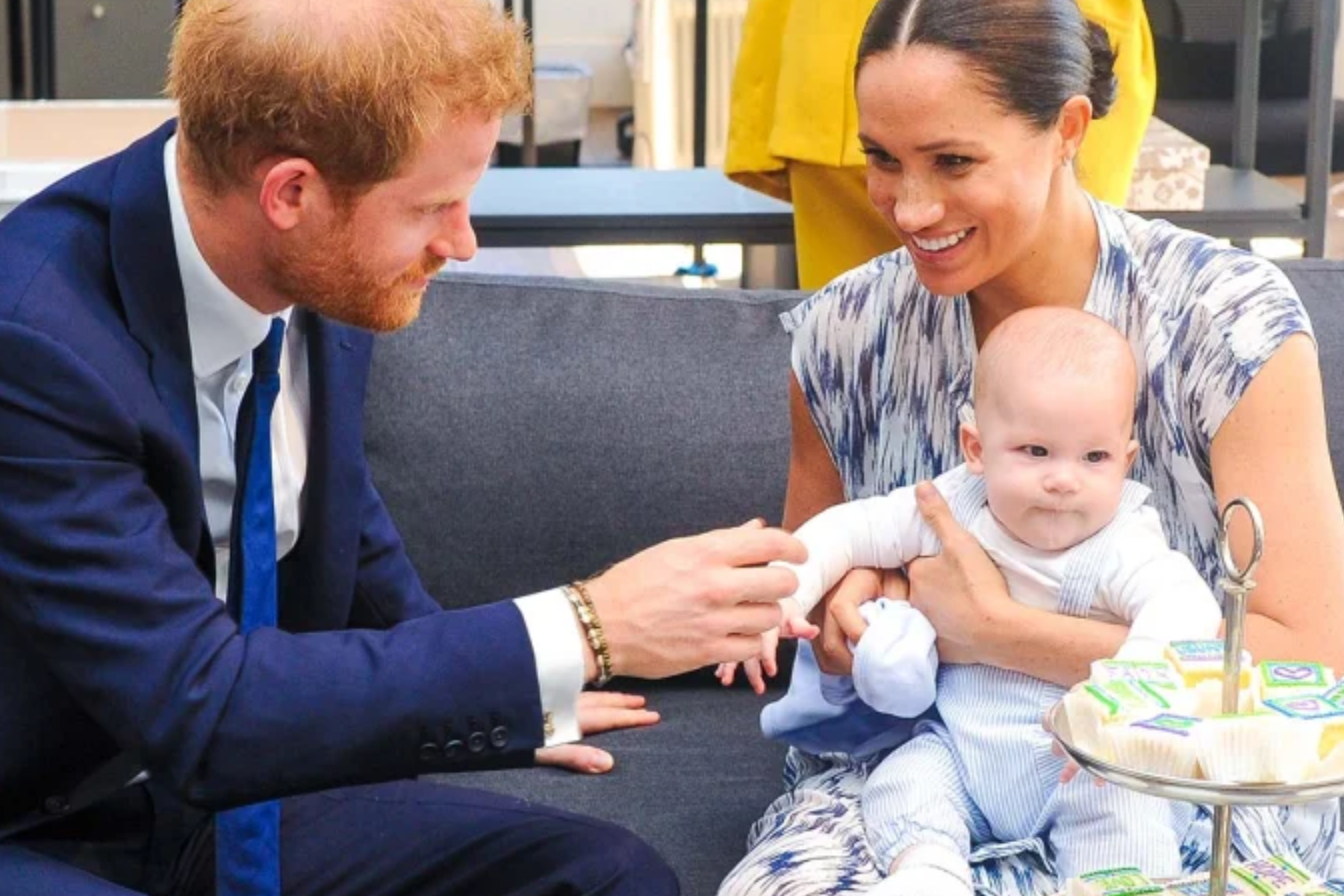 While sitting on a sofa, Prince Harry and Meghan Markle hold their baby