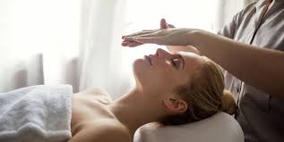 A beautiful woman lying feeling relaxed while receiving reiki