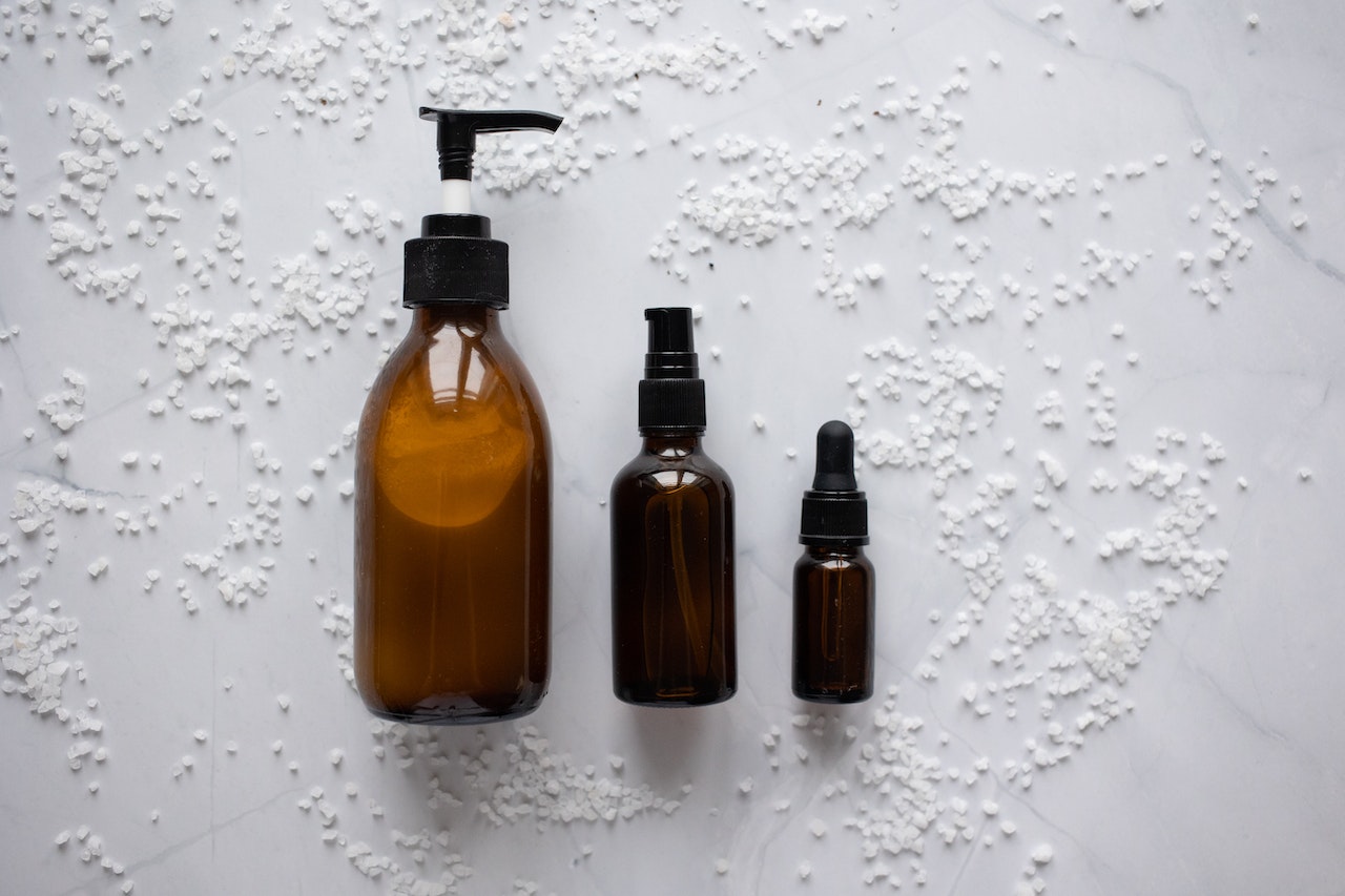 Bottles of essential oil products placed on white surface