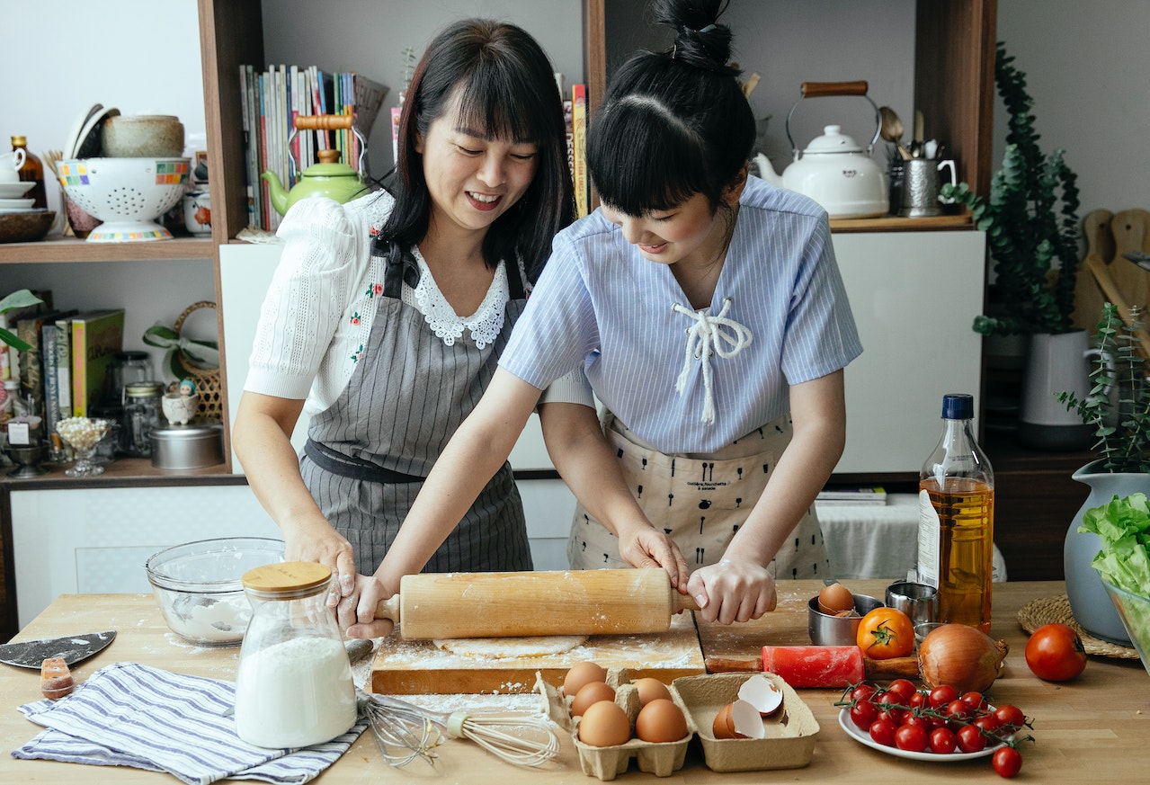 Asian women cooking together in kitchen