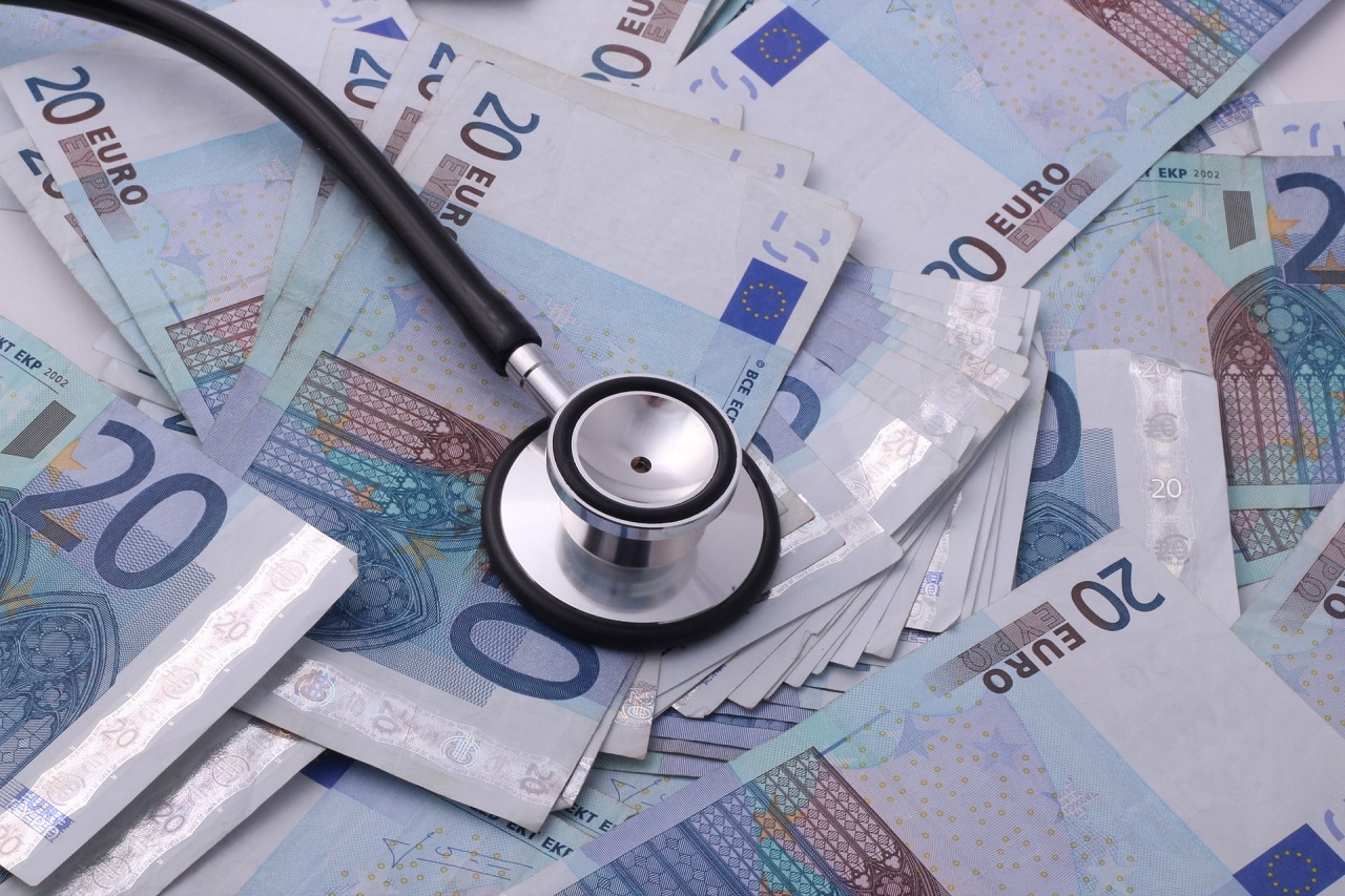 A black stethoscope on top of a pile of 20-Euro bills