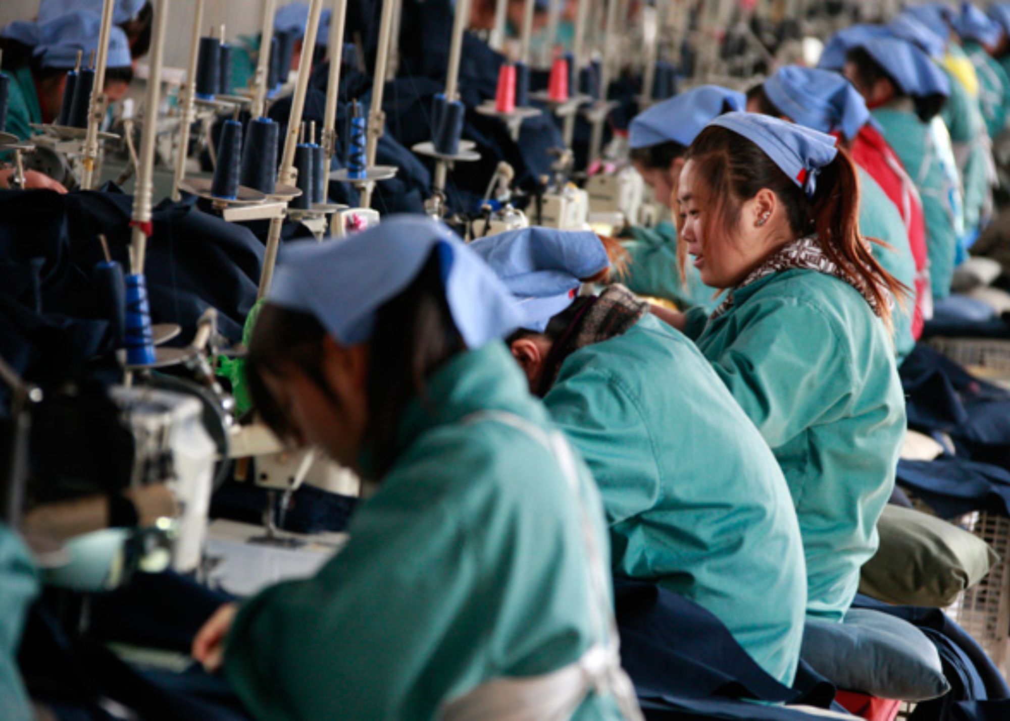 Chinese workers are tailoring while wearing a skyblue scarf on top of their heads