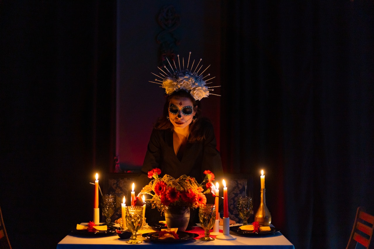 Woman with Face Paint Near Lit Candles