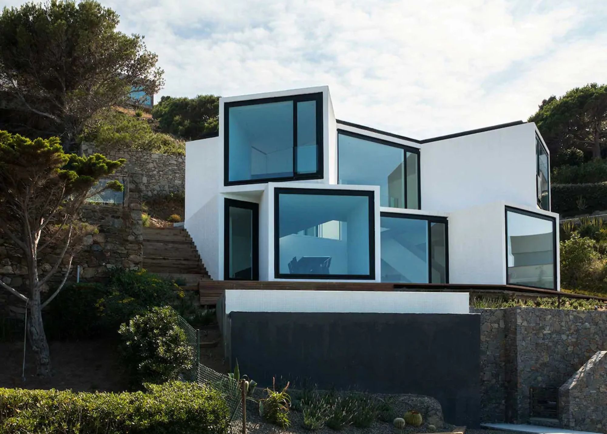 The sunflower house is painted in white color and design in a challenging clifftop location