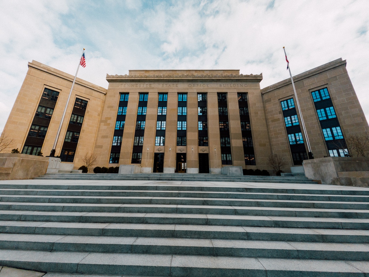 Façade of the U.S. Federal Reserve System and a flagpole on each side, with the American flag on the left side