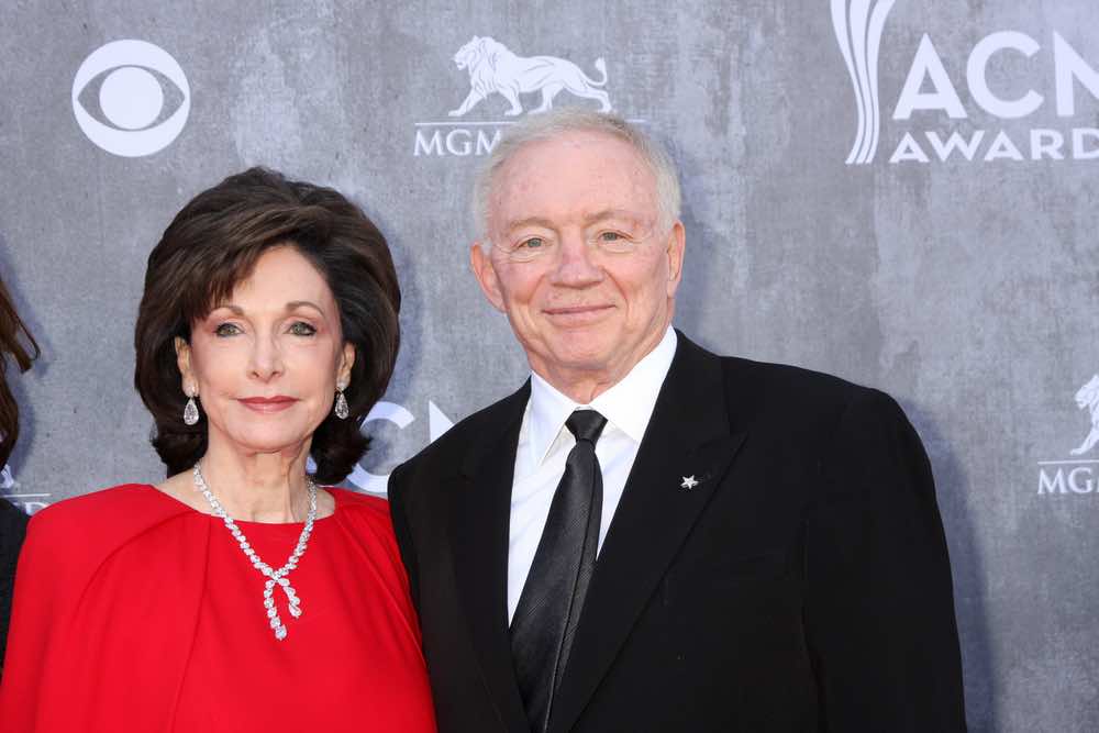 Eugenia Jones wearing a red gown with her husband, Jerry Jones, wearing a black suit