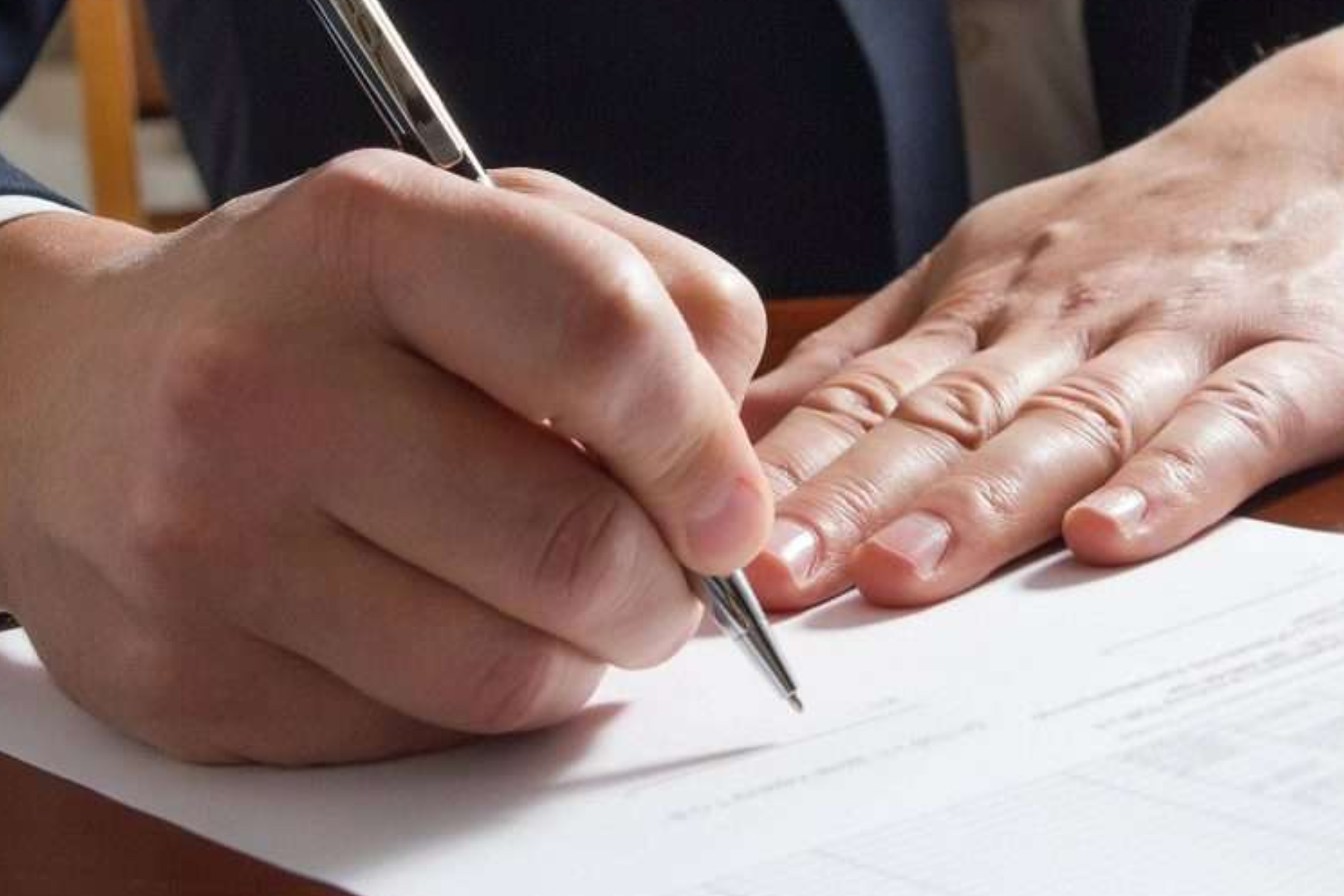 A man's hand processing a marriage license application