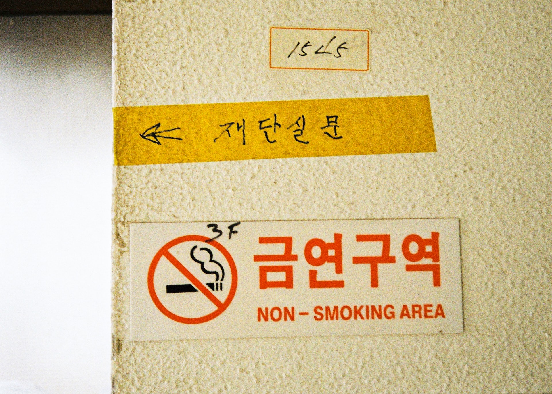 A ‘non-smoking area’ sign on a wall in Korean with English translation