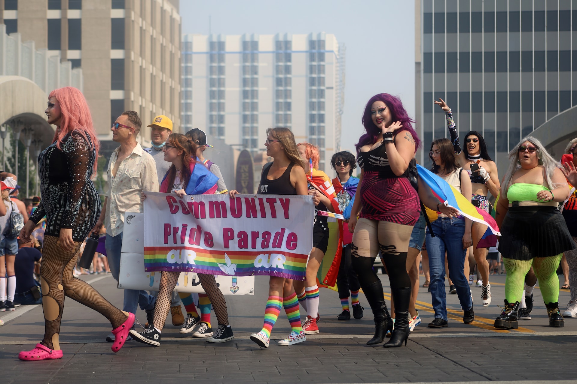 LGBTQ+ individuals in a pride march in Reno, Nevada, with a banner that says ‘CommUnity Pride Parade’