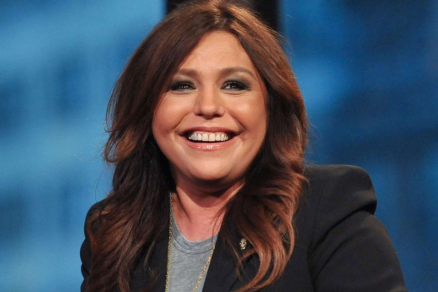 Rachael Ray wearing a black suit with a big smile