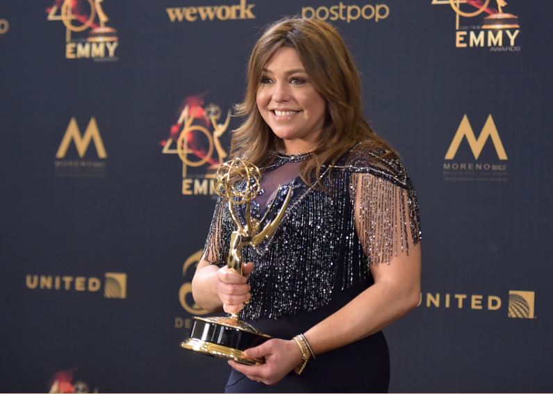Rachael Ray wearing a blue gown as she holds her award in the Emmy Awards event