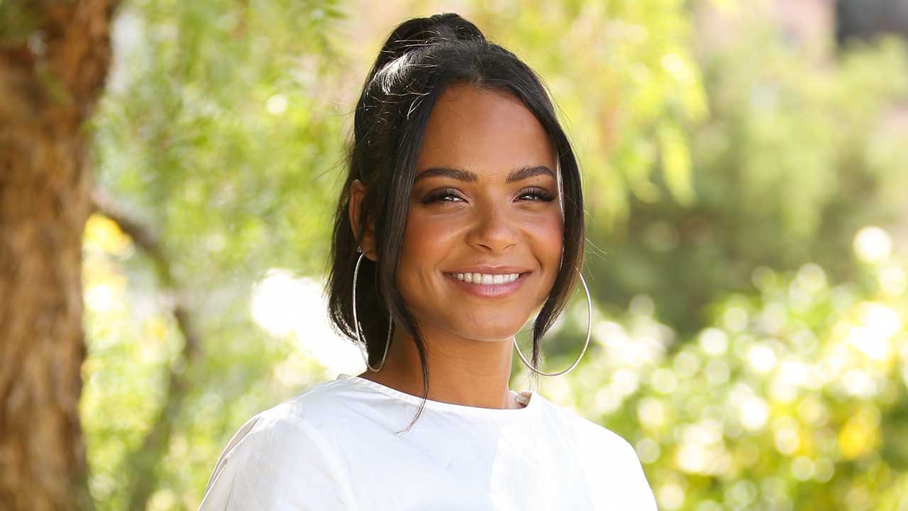 Christina Milian wearing white with a smile on her face