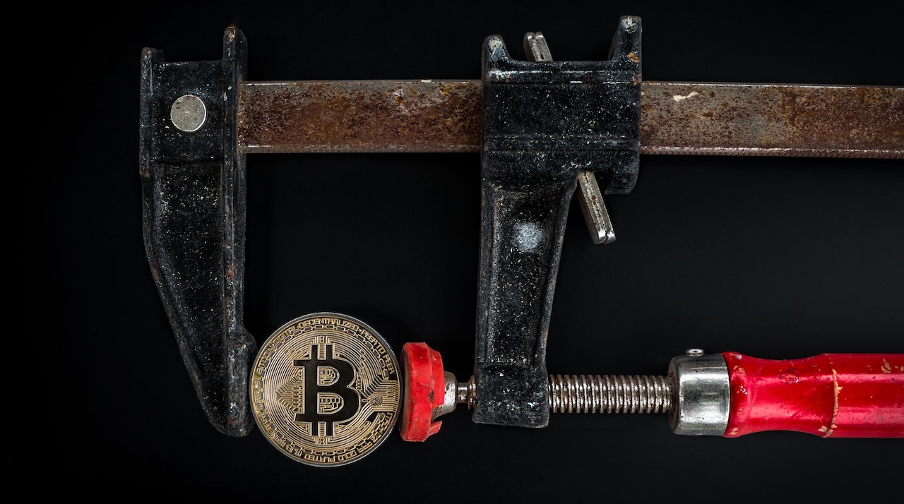Black and Red Caliper on Gold-colored Bitcoin