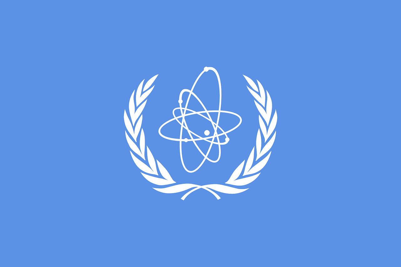 The light blue logo of the International Atomic Energy Agency with its crest-and-spinning-atom emblem in white