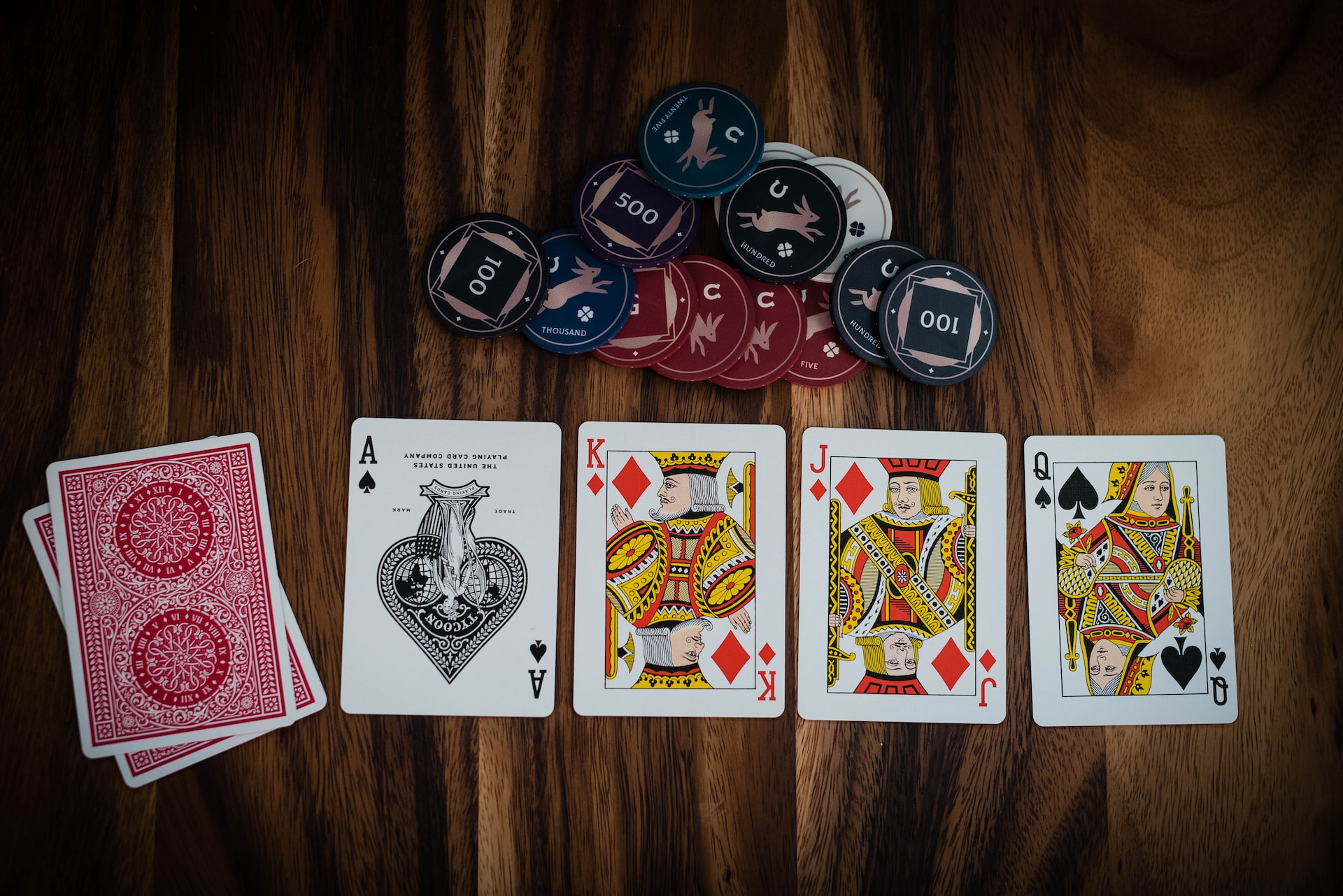 Four opened cards and two closed cards laying beside several casino chips