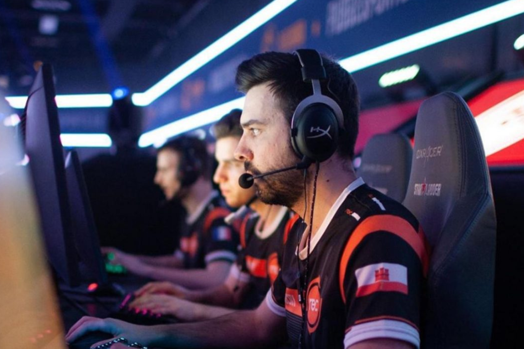 A man wearing earbuds and a headphone while playing with his teammates