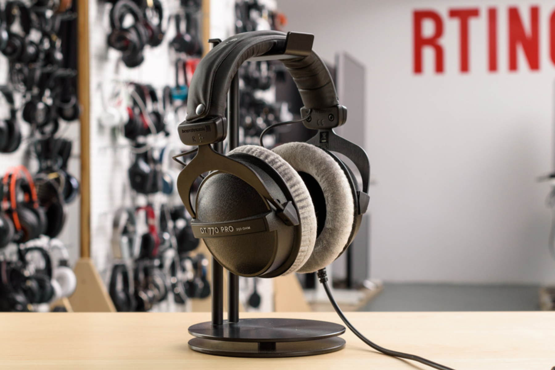 A closed-back over-ear headphone model, the Beyerdynamic DT 770 Pro, is seen resting on a flat surface