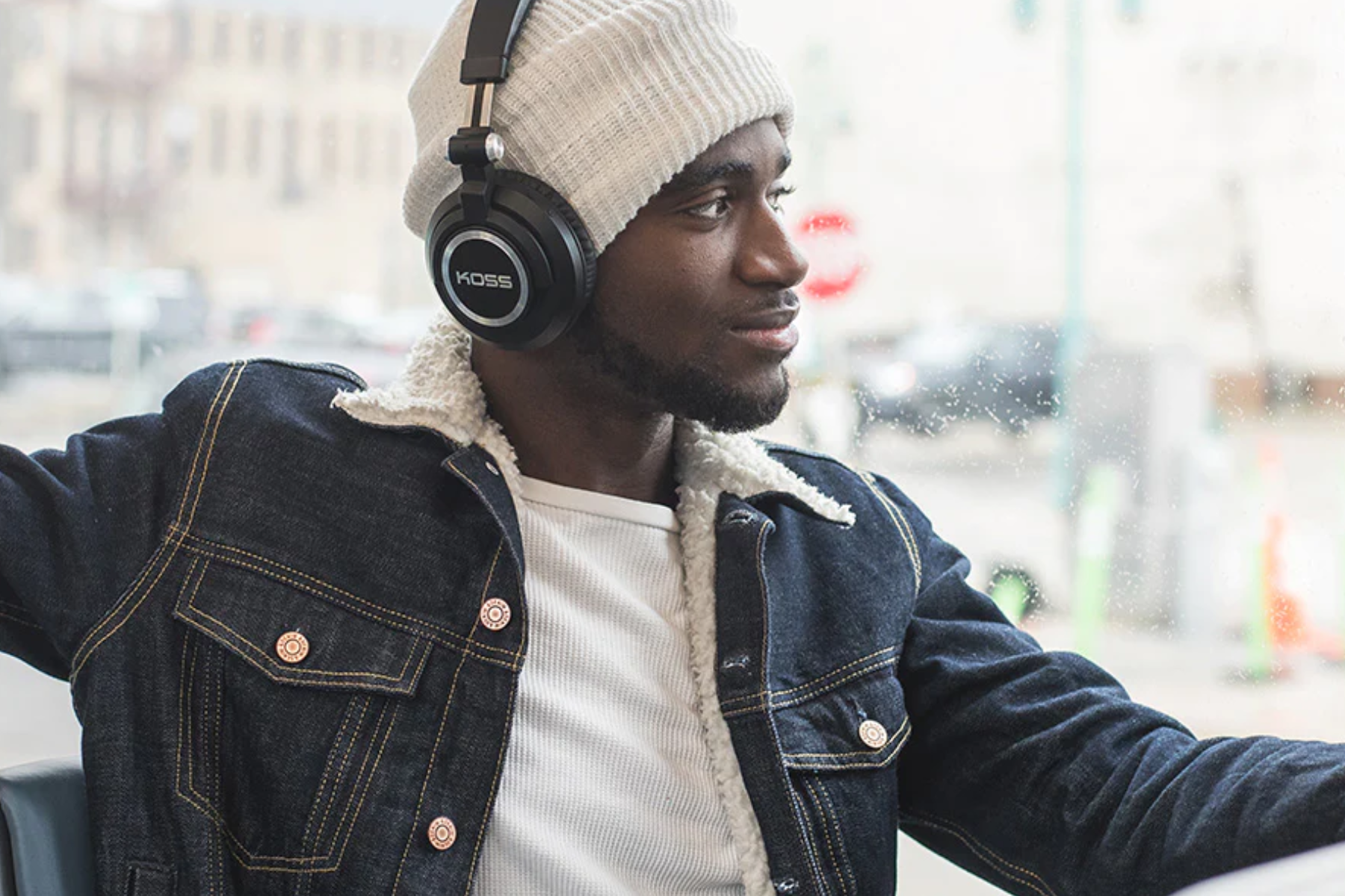 A man with dark skin wearing wireless headphones