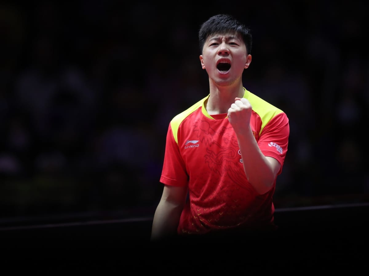 Ma Long shouting while wearing a red and yellow jersey