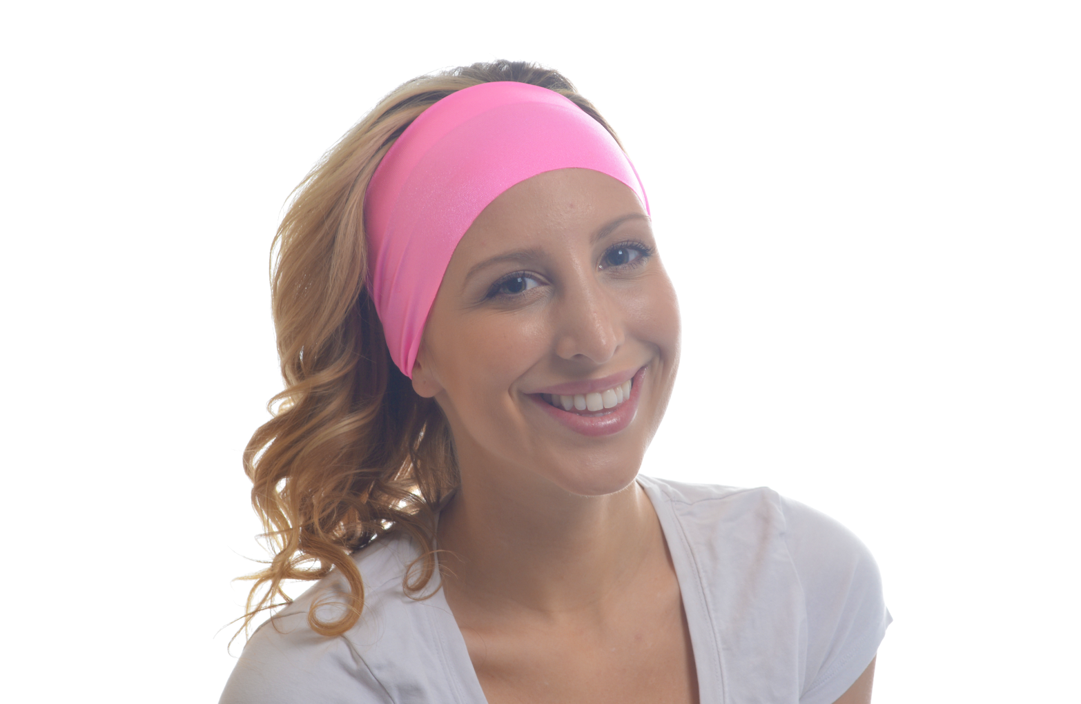 A woman wearing a pink ItFit headband with a big smile on her face