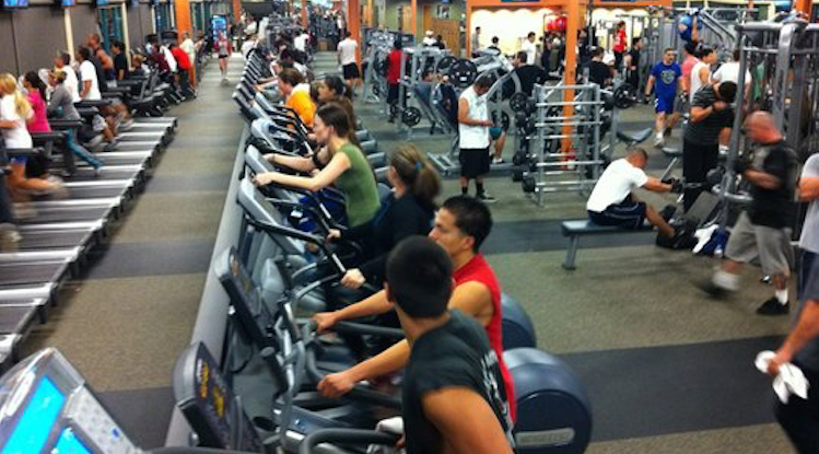 Crowded gym with people working out on treadmills
