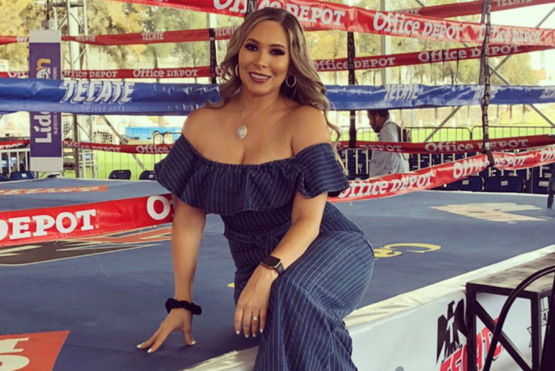 Frida Chávez in a blue dress sitting outside a boxing ring