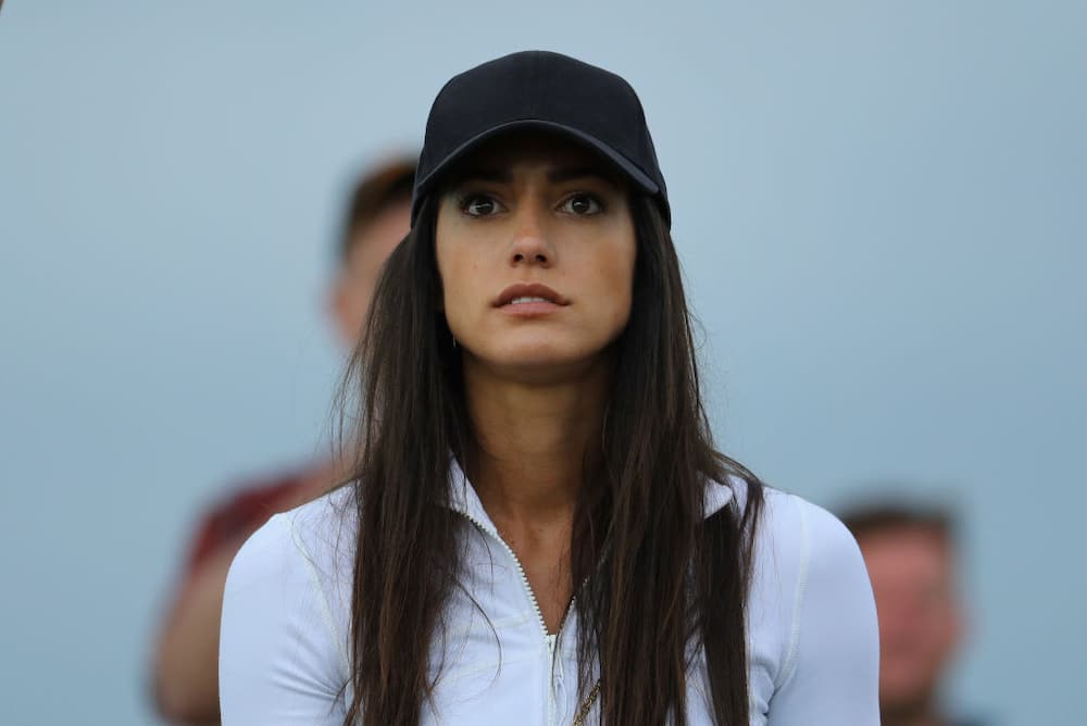 Allison Stokke wearing a white jacket and black cap