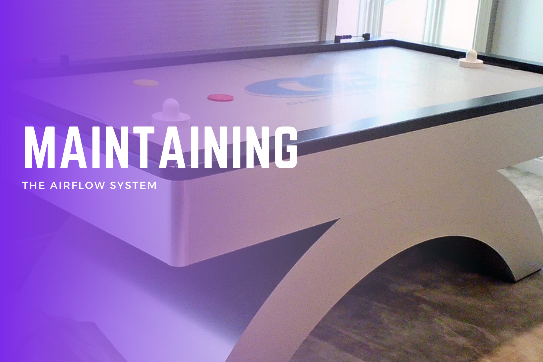 A large Air Hockey Table positioned beside a sign that reads "Maintaining The Airflow System"