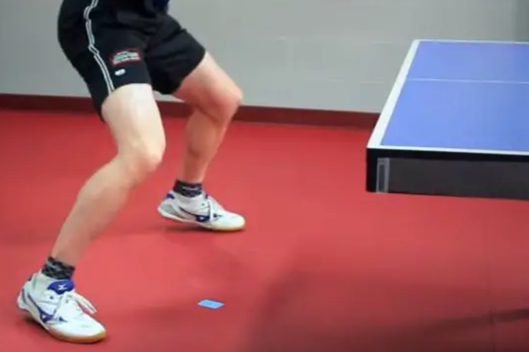 An individual performing footwork while playing ping-pong