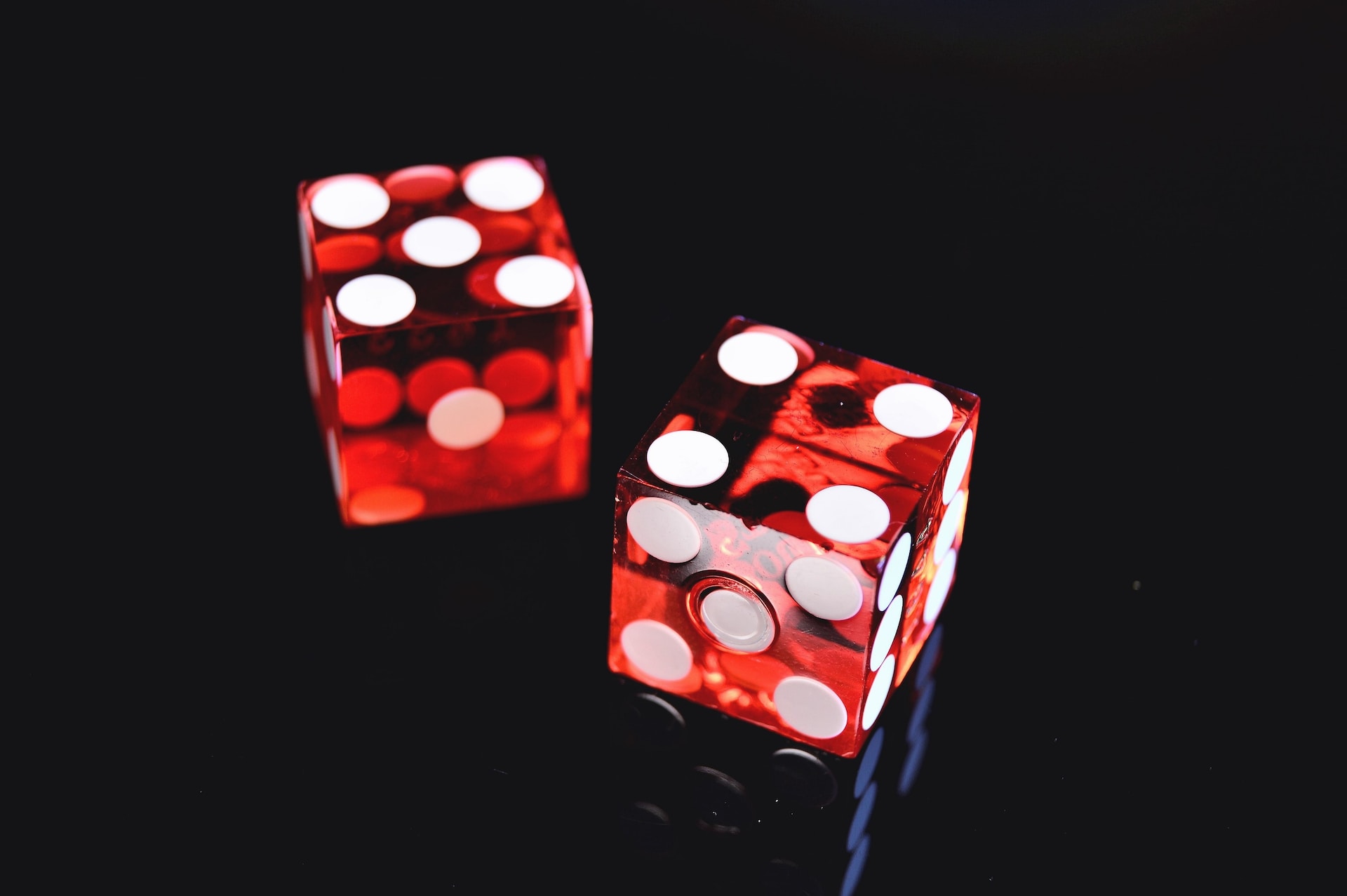 Two transparent red dice against a black background, showing five and four