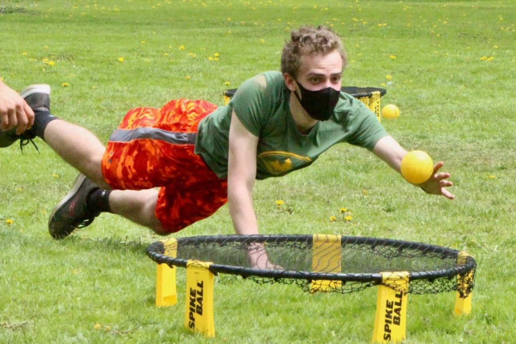 A person playing Spikeball catches the ball