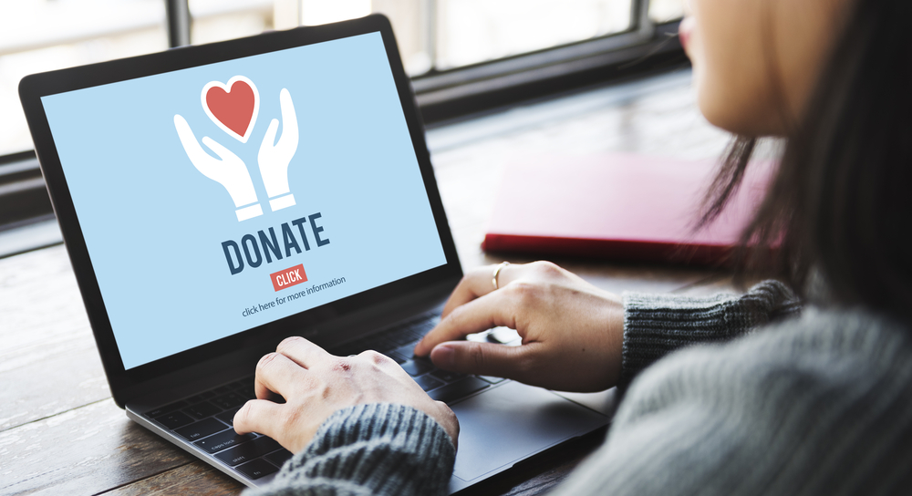 A woman on her laptop with an open donation webpage.