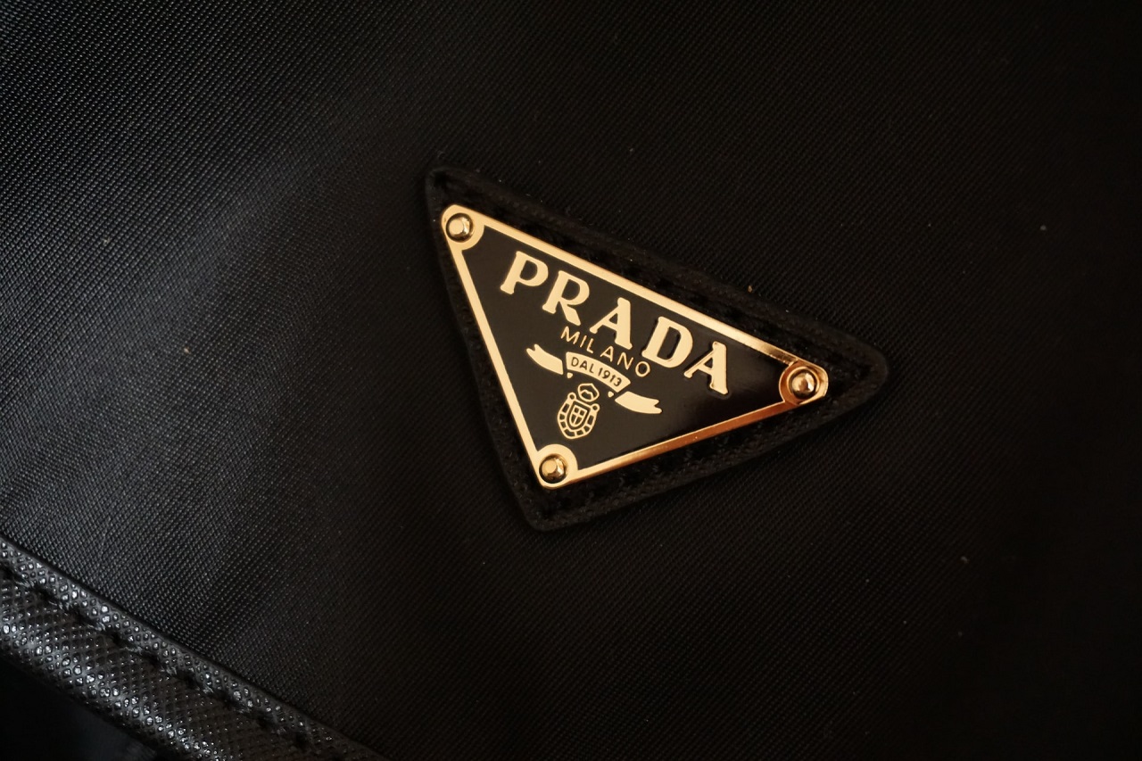 The inverted triangle Prada logo on a black denim jacket