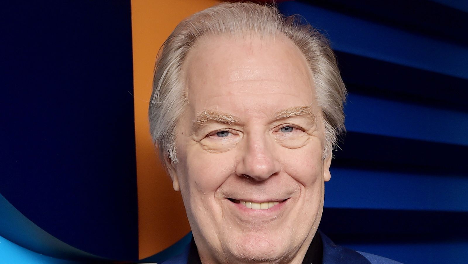 Michael McKean wearing a blue suit and smiling